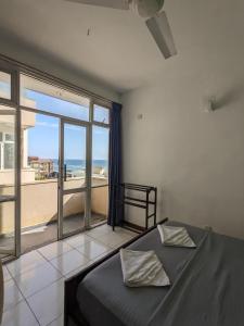 um quarto com uma cama e vista para o oceano em Palmyrah Residencies em Colombo