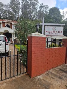 a black fence with a sign in front of a church at Narmada Holiday Home in Ooty