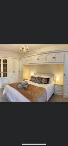 een slaapkamer met een groot bed en witte kasten bij Horne Cottage Ilfracombe (10 mins Woolacombe) in Ilfracombe