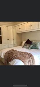 een bed met witte kasten en een deken erop bij Horne Cottage Ilfracombe (10 mins Woolacombe) in Ilfracombe