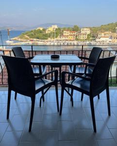 a table and chairs on a balcony with a view at Villa Perris Studios in Kassiopi