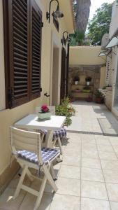 a patio with a table and a bench and a table at Alla Corte di Dionisio in Siracusa