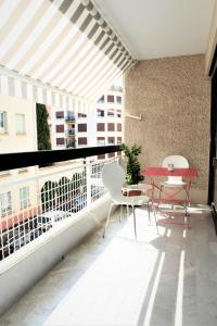 d'un balcon avec une table et des chaises rouges. dans l'établissement Appartement T3 plein centre, à Saint-Raphaël