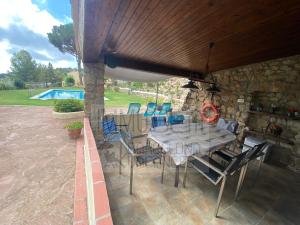 - une table et des chaises sur une terrasse avec piscine dans l'établissement Bv-am 001-can Palome., à Arenys de Munt