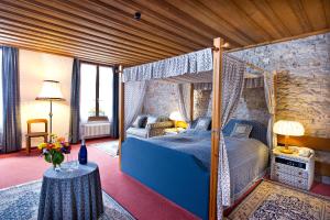 um quarto com uma cama de dossel e uma mesa em Hotel guter Hirte em Huttwil