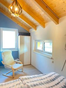 アルノルトシュタインにあるKWO-villa Sonnenglückのベッドルーム1室(ベッド1台、椅子、窓付)