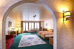 um quarto de hotel com uma arcada com uma sala de estar em Hotel guter Hirte em Huttwil