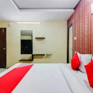a bedroom with a large white bed with red pillows at Hotel Maruthi Residency Inn L B Nagar in Surūrnagar