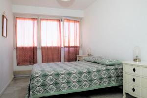 a bedroom with a bed and two windows at Appartement T3 plein centre in Saint-Raphaël