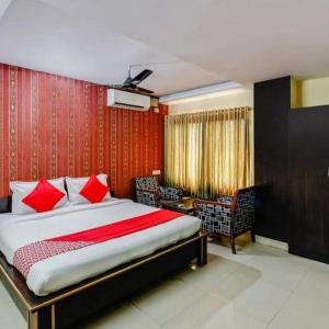 a bedroom with a bed and a red wall at Hotel Maruthi Residency Inn L B Nagar in Surūrnagar