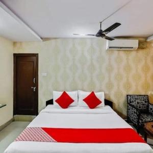 a bedroom with a large bed with red pillows at Hotel Maruthi Residency Inn L B Nagar in Surūrnagar