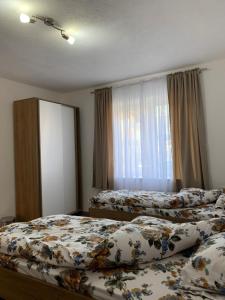 - une chambre avec 2 lits et une fenêtre dans l'établissement Lejla's guesthouse, à Gusinje