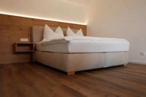 - une chambre avec un lit doté de draps et d'oreillers blancs dans l'établissement Keuschengut, à Oberaichwald