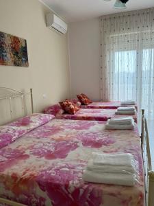 トリカーゼにあるLe Stanze di Lucia vicino Ospedale Cardinale Panico a Tricaseのピンクのシーツとタオルが備わるベッド3台付きの部屋