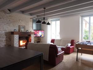 Una sala de estar con un sofá y una chimenea. en Jolie charentaise dans la campagne de saintonge, en Saint-Mandé-sur-Brédoire