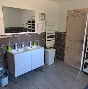 Un baño con dos lavabos y un espejo grande. en Jolie charentaise dans la campagne de saintonge, en Saint-Mandé-sur-Brédoire