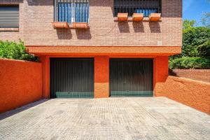 um edifício com duas portas de garagem e duas cadeiras em Casa Cafe Madrid (El plantio) Calle segundo anca 11 madrid 28023 em Madri