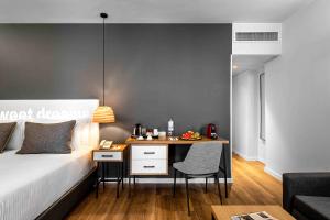 a bedroom with a bed and a desk with a chair at Prima City Hotel in Tel Aviv