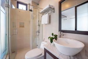 uma casa de banho com um lavatório, um WC e um chuveiro em Hoi An Ivy Hotel em Hoi An