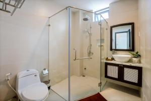 a bathroom with a glass shower and a sink at Hoi An Ivy Hotel in Hoi An