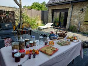 a table with food on it in a backyard at Ô Chambres d'Hôtes 