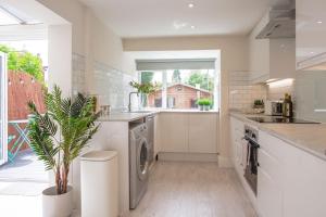 uma cozinha com um lavatório e uma máquina de lavar louça em Stunning Townhouse with Large Garden - Sleeps 8! em Cheltenham