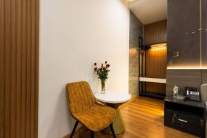 a room with a table and a chair and flowers at MICASA HOTEL in Ho Chi Minh City