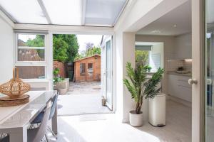 a kitchen and dining room with a table and a plant at Stunning Townhouse with Large Garden - Sleeps 8! in Cheltenham