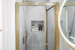 a bathroom with a shower with a mirror at Livestay-Luxury Kentish Town Apartments in London