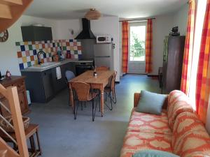a kitchen and living room with a table and a couch at Le moulin de la Chaîrâ 