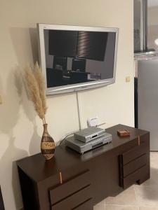 a table with a television and a vase on it at Villa Rada, Bay View Villas in Kosharitsa