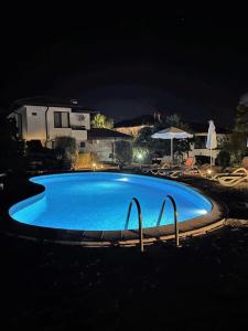 a large blue swimming pool at night at Villa Rada, Bay View Villas in Kosharitsa