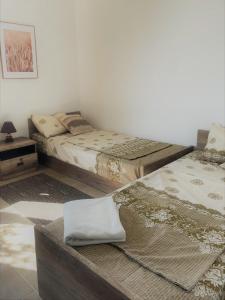 Habitación con 2 camas y mesa. en Villa Rada, Bay View Villas, en Kosharitsa