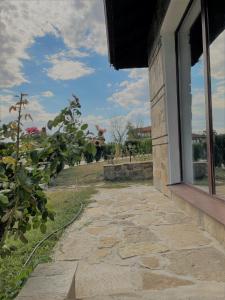 a stone walkway next to a window of a building at Villa Rada, Bay View Villas in Kosharitsa