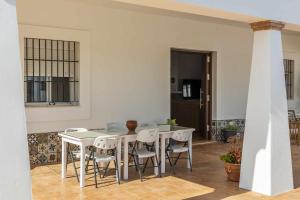 ein weißes Esszimmer mit Tisch und Stühlen in der Unterkunft Casa Rural Brisa del Valle in La Puebla de Cazalla