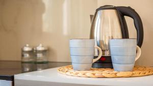 two cups sitting on top of a coffee maker at Stylish Extra - BIG 1+1 Central Apt in Himare