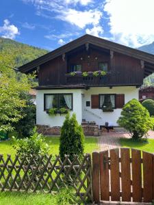 une maison avec une clôture devant elle dans l'établissement Ferienhaus Anni, à Kreuth