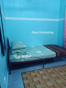 Bett in einem Zimmer mit blauer Wand in der Unterkunft ALYA HOMESTAY TAMAN TAMBAK PAYA MURNI in Malakka + 2 Fotos