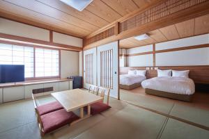 a room with two beds and a table and a tv at サザンシティホテル in Nankoku +39 photos