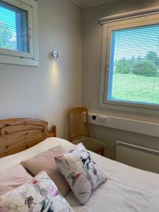 a bedroom with a bed with two pillows and a window at Puuppola Kotikoivu 