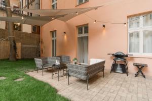 a patio with chairs and a grill in a yard at MIZU House by Prague Days in Prague