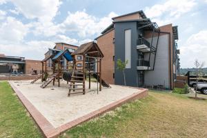 a playground in front of a house at Modern 2 bed apartment, Secure estate in Midrand