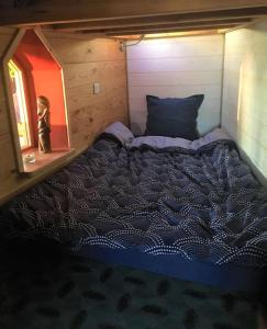 a bedroom with a bed in a tiny house at La Petite Maison du hÊtre in Brassac
