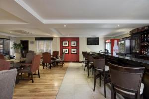 a restaurant with a bar and tables and chairs at Protea Hotel by Marriott Mahikeng in Mahikeng