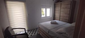 a small bedroom with a bed and a window at Budva stan Natasa in Budva