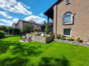 un cortile con prato verde e una casa di Pension Waldblick a Heidenheim an der Brenz