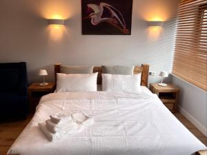 a bedroom with a white bed with white sheets and pillows at Kosa Śpiew in Kosewo