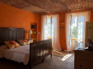 um quarto com uma cama e 2 janelas grandes em CASCINA BELLAVISTA - Luxury Country Villa + Pool 