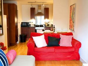 a red couch with pillows in a living room at Pass the Keys Bohemian Ancoats suite with balcony in Manchester