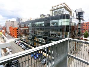 a large building with a parking lot in a city at Pass the Keys Bohemian Ancoats suite with balcony in Manchester